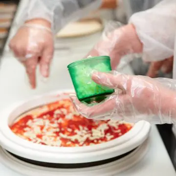 Kuharji pripravljajo jed z nošenjem prozornih PVC rokavic za enkratno uporabo