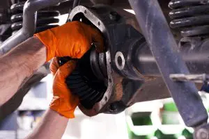 Oranžne Nitril rokavice v uporabi pri avtomehaniku