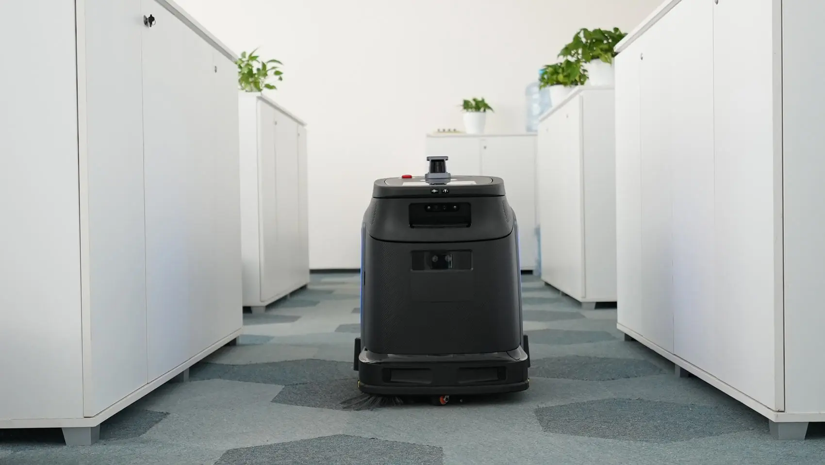 Robot Gausium Phantas pri čiščenju pisarniških tal s preprogo.