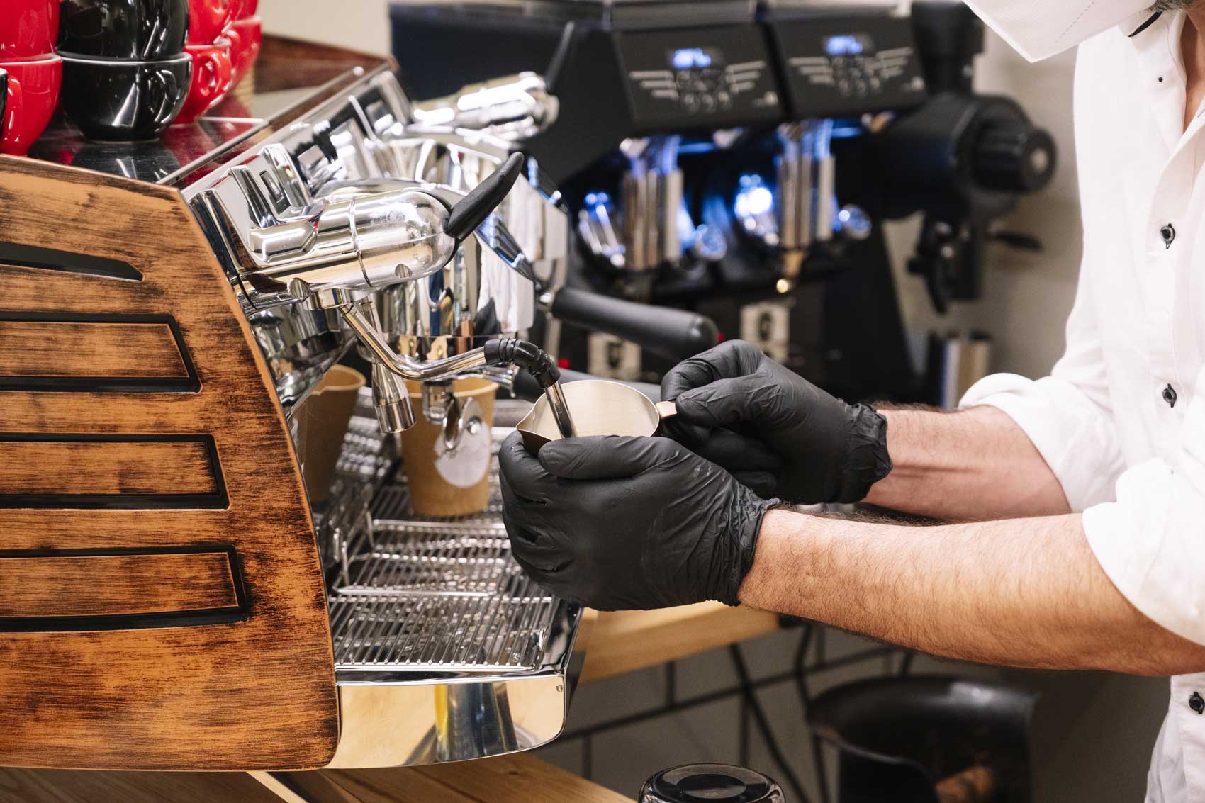 Barista pri kuhanju kave uporablja črne rokavice iz nitrila