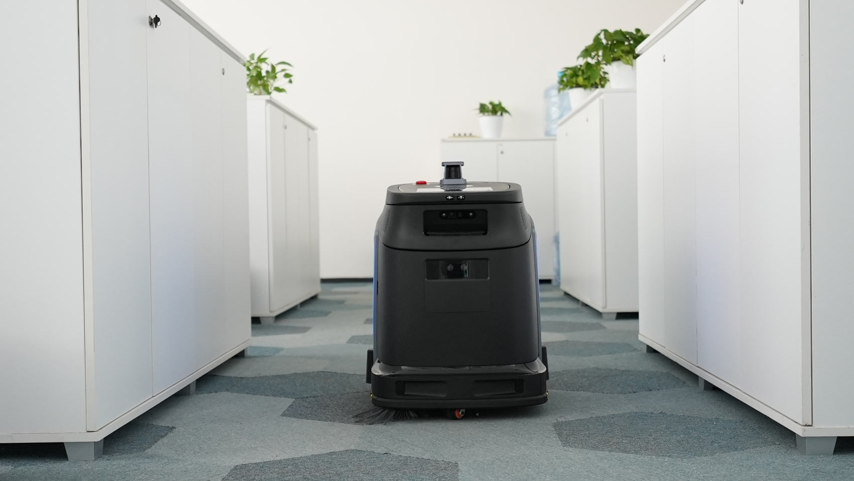 Robot Gausium Phantas pri čiščenju pisarniških tal s preprogo.